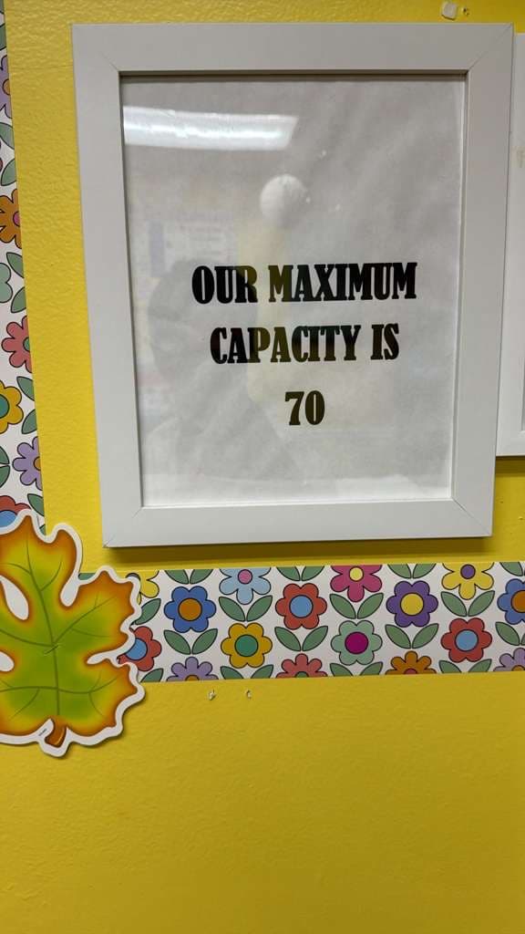 Framed sign reading 'Our maximum capacity is 70' in the FCIA hallway.
